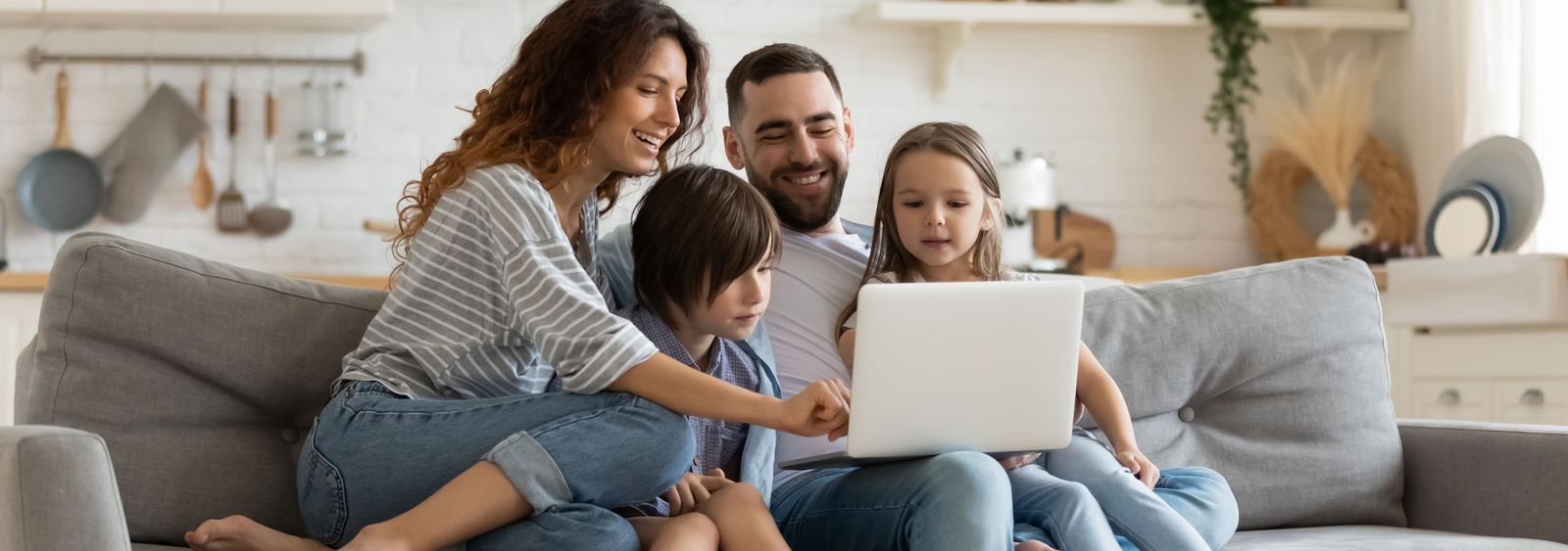 Familie auf Sofa informiert sich über die günstigsten Internet Abos