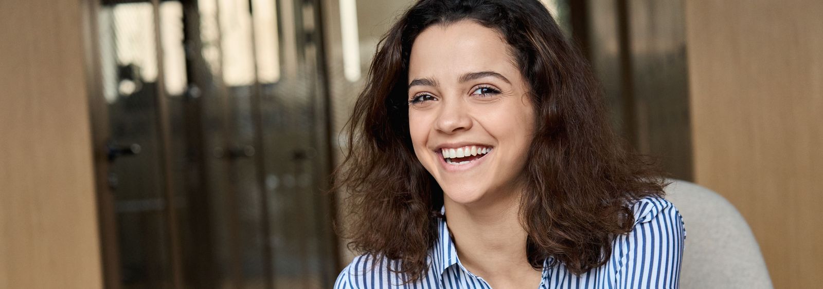 Lachendes, sitzendes Mädchen mit Mobile in der Hand